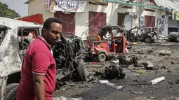 Seorang pria berjalan melewati reruntuhan di lokasi pemboman di Mogadishu, Somalia (13/2/2021). Mobil yang membawa bom itu melaju melalui pos pemeriksaan di depan Hotel Wehliye yang cukup populer di kalangan pejabat setempat dan kelompok elite Somalia. (AP Photo/Farah Abdi Warsameh)