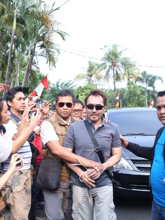 Pukul 16.07 WIB, Gatot tiba dengan mengenakan kaos, berkaca mata hitam dan tas kecil warna hitam.  Kedua tangan Gatot diikat dengan menggunakan cabel ties. (Nurwahyunan/Bintang.com)