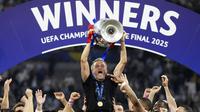 Pelatih PSG, Luis Enrique mengangkat trofi Liga Champions 2024/2025 setelah berhasil mengalahkan Inter Milan dalam laga final yang berlangsung di Allianz Arena, Munchen, Jerman, Minggu (01/06/2025) dini hari WIB. (AP Photo/Matthias Schrader)