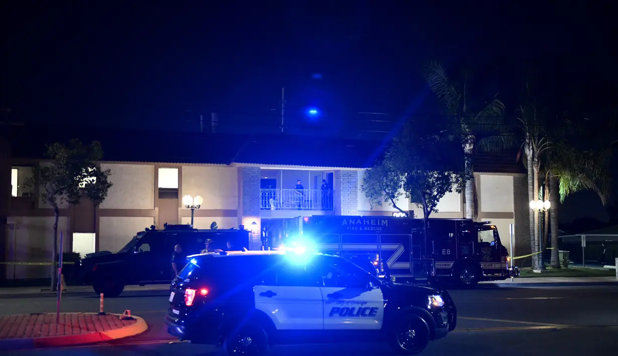 Petugas polisi berdiri di luar gedung perkantoran, beberapa orang tewas dalam penembakan di Orange, California (31/3/2021).  Pihak berwenang mengatakan bahwa empat orang, termasuk seorang anak, tewas dalam penembakan dan dua lainnya telah diangkut ke rumah sakit setempat. (AFP/Patrick T. Fallon)