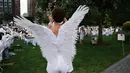 Seorang wanita dengan mengenakan sayap menghadiri Diner en blanc di Rockefeller Park, New York, Rabu (17/7/2019). New York City Diner en Blanc adalah sebuah pesta makan malam rahasia dengan pakaian bernuansa putih yang diadopsi dari budaya Prancis. (TIMOTHY A. CLARY / AFP)