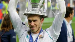 Pemain depan Real Madrid Gareth Bale mengangkat piala saat merayakan kemenangannya usai melawan Liverpool pada pertandingan final Liga Champions di Stadion NSK Olimpiyskiy, Ukraina (26/5). (AP/Efrem Lukatsky)
