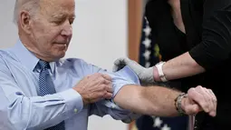 Presiden Joe Biden menggulung lengan bajunya sebelum disuntik dosis keempat vaksin COVID-19 Pfizer keduanya di South Court Auditorium, Gedung Putih, Rabu (30/3/2022). AS pada Selasa mengizinkan orang berusia di atas 50 tahun dan kondisi rentan bisa menerima booster kedua. (AP Photo/Patrick Semansky)