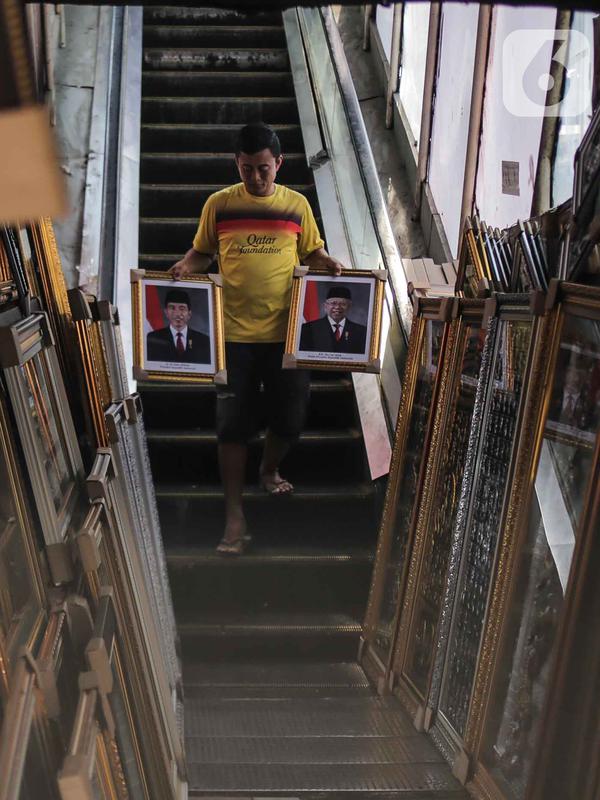 Pedagang membawa bingkai foto Presiden Joko Widodo dan Wakil Presiden terpilih Ma'ruf Amin yang dijualnya di Pasar Baru, Jakarta, Rabu (16/10/2019). Harga bingkai foto Presiden dan Wakil Presiden tersebut dijual mulai dari harga Rp 90 ribu. (Liputan6.com/Faizal Fanani)