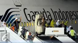 Ratusan jamaah Haji Indonesia embarkasi DKI Jakarta keluar dari pesawat saat tiba di Bandara Halim Perdanakusuma Jakarta, Selasa (29/9/2015). Sebanyak 440 jamaah dengan tiba sekitar pukul 18.30 WIB. (Liputan6.com/Helmi Fithriansyah)