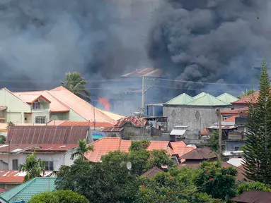 Kepulan asap terlihat menyusul serangan udara oleh Angkatan Udara Filipina ke kawasan yang telah di kuasai militan Maute di kota Marawi , Filipina selatan Sabtu, (27/5). (AP Photo / Bullit Marquez)