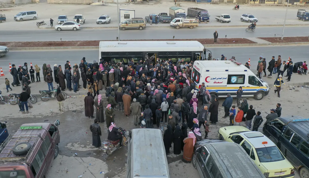 Foto udara menunjukkan pengungsi Suriah yang tinggal di Turki menunggu untuk naik bus melalui penyeberangan perbatasan Bab al-Hawa utara, pada 17 Februari 2023, saat mereka kembali ke Suriah setelah gempa bumi yang mematikan. Turki minggu ini mengizinkan warga Suriah di bawah perlindungannya yang memegang kartu identitas dari salah satu provinsi yang dilanda gempa untuk pergi antara tiga dan enam bulan. (AFP/Omar Haj Kadour)