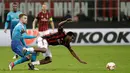 Pemain AC Milan, Franck Kessie tersungkur saat berebut bola dengan pemain Arsenal Aaron Ramsey pada pertandingan Liga Europa leg pertama di stadion San Siro Milan, Italia (8/3). AC Milan takluk 0-2 dari Arsenal. ( AP Photo / Luca Bruno)