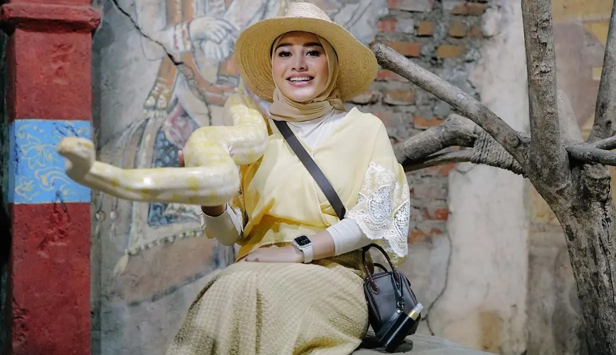 Kala ke Bali Zoo tahun lalu, Aurel Hermansyah memilih blus beraksen renda dipadukan dengan plaid skirt warna kuning cerah.