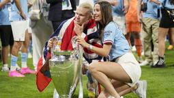 Pemain Manchester City, Erling Haaland, berpose bersama kekasihnya Isabel Haugseng Johansen saat perayaan gelar juara Liga CHampions di Ataturk Olympic Stadium, Istanbul, Minggu (11/6/2023). Erling Haaland tampil luar biasa dan mampu meraih treble winner di musim perdananya bersama City. (AP Photo/Francisco Seco)