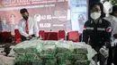Petugas menata barang bukti terkait upaya penyelundupan narkoba jaringan Malaysia saat rilis di Gedung Bareskrim Mabes Polri, Jakarta, Selasa (30/3/2021). Total barang bukti yang disita ada 42 kilogram lebih narkotika jenis sabu dan 83 ribu butir pil ekstasi. (Liputan6.com/Faizal Fanani)