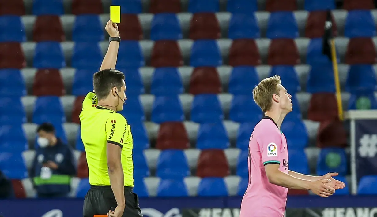 Wasit memberikan kartu kuning kepada gelandang Barcelona, Frenkie de Jong (kanan) saat melawan Levante dalam laga lanjutan Liga Spanyol 2020/2021 pekan ke-36 di Ciutat de Valencia Stadium, Valencia, Selasa (11/5/2021). Barcelona bermain imbang 3-3 dengan Levante. (AP/Alberto Saiz)