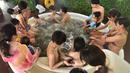 Petugas memberikan cokelat kepada pengunjung saat mandi spa cokelat di Hakone, Jepang, Senin (13/2). Mandi spa cokelat ini digelar setiap tahun bulan Februari. (AFP PHOTO / Kazuhiro Nogi)