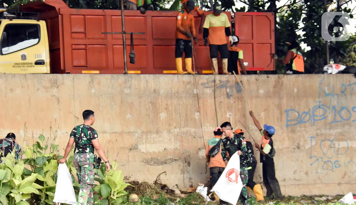 Personel gabungan memindahkan sampah ke dalam truk saat kegiatan Grebeg Kali Ciliwung. (Liputan6.com/Herman Zakharia)