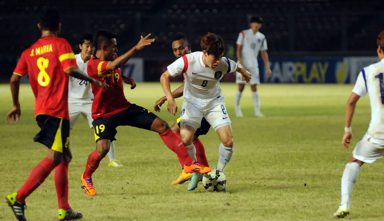 Pemain tengah timnas Korea Selatan U-23, Lee Changmin (8) berusaha lolos dari kepungan pemain Timor Leste di laga kualifikasi Piala Asia 2016 di Stadion GBK Jakarta, (29/3/2015). Korea Selatan unggul 3-0 atas Timor Leste. (Liputan6.com/Helmi Fithriansyah)
