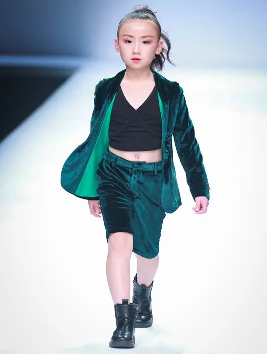 Seorang model anak menampilkan koleksi busana dari KUNJIE karya Liu Shuming pada gelaran China Fashion Week di Beijing, China, Selasa (27/10/2020). (STR / AFP)
