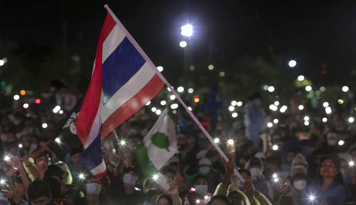 Pengunjuk rasa pro-demokrasi mengibarkan bendera selama protes di Sanam Luang di Bangkok, Thailand (19/9/2020). Para pengunjuk rasa mengulangi tuntutan agar monarki Thailand tetap berada di bawah konstitusi dalam demonstrasi terbesar sejak kudeta militer pada 2014. (AP Photo/Wason Wanichakorn)