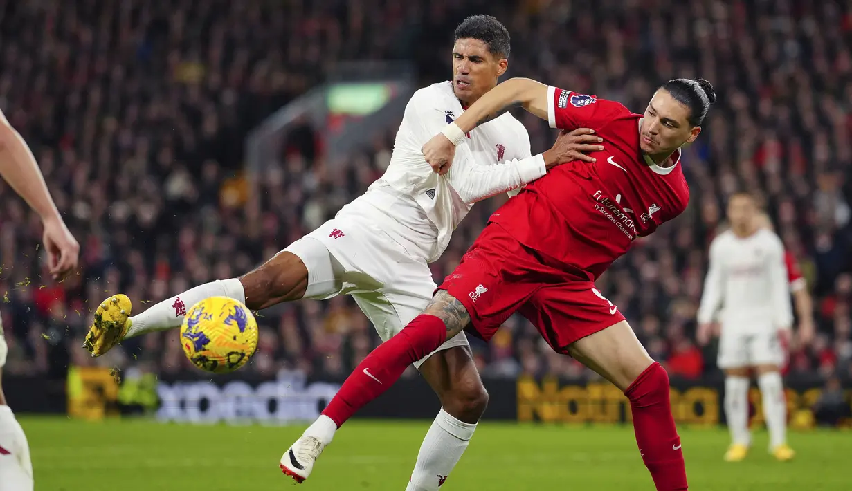 <p>Pemain Manchester United, Raphael Varane (kiri) berebut bola dengan pemain Liverpool,&nbsp;Darwin Nunez pada laga lanjutan Liga Inggris 2023/2024 di Anfield, Liverpool, Inggris, Rabu (18/12/2023) dini hari WIB. (AP Photo/Jon Super)</p>