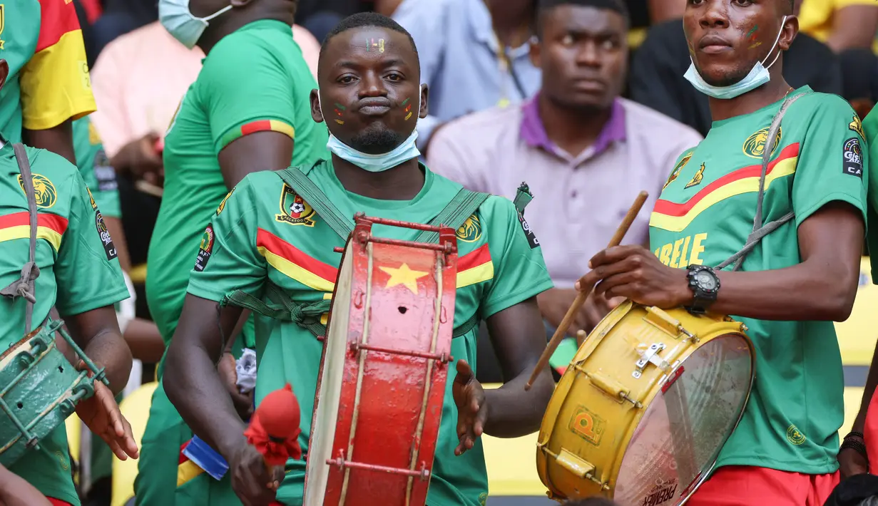 Suporter Kamerun bermain drum menjelang upacara pembukaan turnamen sepak bola Piala Afrika (CAN) 2021 di Stade d'Olembé di Yaounde (9/1/2022). Piala Afrika 2021 seharusnya digelar Januari 2021 tapi kemudian diundur karena pandemi. (AFP/Kenzo Tribouillard)