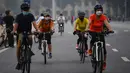 Orang-orang mengendarai sepeda di sepanjang jalan di Hanoi setelah otoritas kota mengizinkan kegiatan olahraga menyusul pelonggaran pembatasan Covid-19, Selasa (28/9/2021). Sejauh ini, 94 persen dari populasi orang dewasa Hanoi telah menerima satu suntikan vaksin COVID-19. (Nhac NGUYEN/AFP)