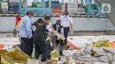 Petugas KNKT memeriksa bagian turbin pesawat Sriwijaya Air dihari kelima yang jatuh di perairan Pulau Seribu, di Dermaga JICT, Jakarta,  Rabu (13/1/2021). Potongan mesin jenis pesawat Boeing 737-500 yang ditemukan di perairan Kepulauan Seribu. (Liputan6.com/Faizal Fanani)
