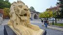 Wisatawan mengunjungi patung singa raksasa dari lego, replika salah satu patung singa dari jembatan tertua Hungaria - Chain Bridge - di Budapest pada 28 Oktober 2022. Bagi warga Budapest, singa adalah simbol penting, dan singa batu di Chain Bridge juga merupakan pemandangan populer. (ATTILA KISBENEDEK / AFP)