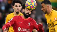 Pemain Liverpool, Mohamed Salah mendappat gangguan dari dua pemain Wolverhampton pada laga di ajang Liga Inggris 2021/2022. (JUSTIN TALLIS / AFP)