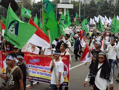 Ratusan massa aksi damai berkumpul di sekitar Bundaran Patung Arjuna Wijaya, Jakarta, Jumat (4/11). Massa berkumpul untuk melakukan aksi di depan Istana Negara menuntut penegakan hukum kasus dugaan penistaan agama. (Liputan6.com/Helmi Fithriansyah)