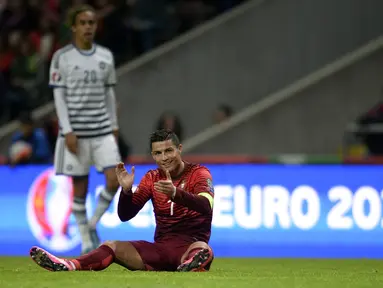 Bintang Portugal Cristiano Ronaldo bertpuk tangan saat terjatuh pada laga Kualifikasi Piala Eropa 2016 Grup I di Municipal stadium, Braga, Kamis (8/10/2015). Portugal menang atas Denmark1-0. (AFP Photo/ Miguel Riopa)