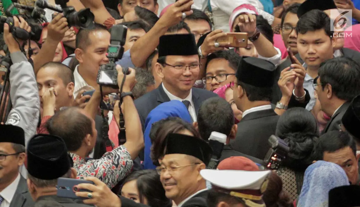 Gubernur DKI Jakarta Anies Baswedan bersalaman dan bertegur sapa dengan gubernur pendahulunya, Basuki Tjahaja Purnama (Ahok) setelah pelantikan anggota DPRD DKI Jakarta periode 2019-2024 di Gedung DPRD DKI Jakarta, Senin (26/8/2019). (Liputan6.com/Faizal Fanani)