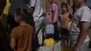 Warga Palestina, termasuk anak-anak, mengambil air dari keran air di tengah kekurangan air minum, di Khan Younis, Jalur Gaza, Minggu, 15 Oktober 2023. (AP Photo/Fatima Shbair)