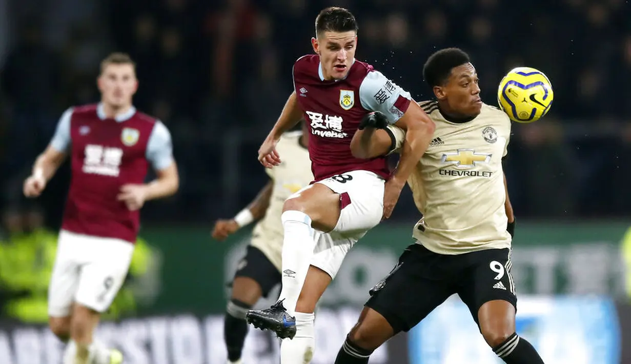Penyerang Manchester United, Anthony Martial, berebut bola dengan pemain Burnley, Ashley Westwood, pada laga Premier League di Stadion Turf Moor, Sabtu (28/12). Burnley takluk 0-2 dari Manchester United. (AP/Martin Rickett)