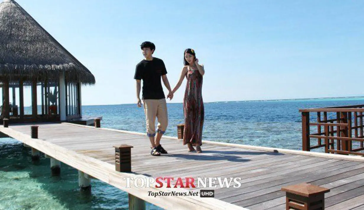 Dalam salah satu foto, Sungmin dan Kim Sa Eun tampak berpegangan tangan sambil berjalan-jalan menyaksikan pemandangan indah di pulau tersebut. (www.koreaboo.com)
