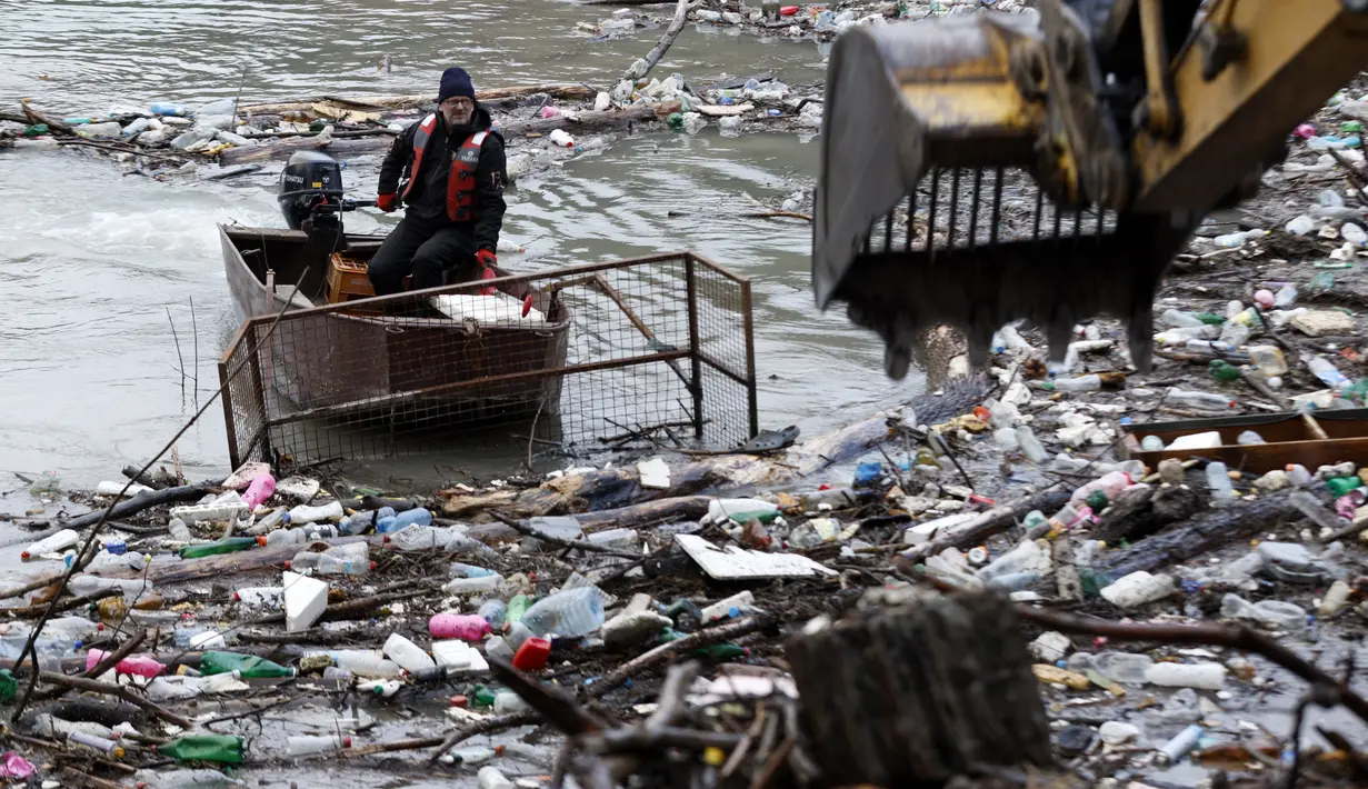 Sebuah derek membersihkan sampah yang tersangkut di danau penimbunan Potpecko dekat Priboj, di barat daya Serbia, Kamis (12/1/2023). Serbia dan negara-negara Balkan lainnya kewalahan oleh sampah komunal setelah beberapa dekade diabaikan dan kurangnya kebijakan pengelolaan limbah yang efisien di negara-negara yang bercita-cita untuk bergabung dengan Uni Eropa. (AP Photo/Marjan Vucetic)