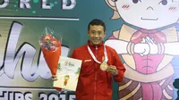 Atlet Wushu Indonesia, Yusuf Widiyanto menerima medali emas pada Kejuaraan Dunia Wushu 2015 di Istora, Senayan, Jakarta, Selasa (17//11/2015). (Bola.com/Nicklas Hanoatubun)