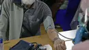 Petugas memeriksa tekanan darah warga lansia sebelum divaksin COVID-19 di Balai Besar Pelatihan Kesehatan (BBPK) Jakarta Kampus Hang Jebat, Jakarta Selatan, Selasa (23/3/2021). Tersedia 1.000 kuota perhari bagi lansia yang berdomisili di dalam dan luar DKI Jakarta. (Liputan6.com/Faizal Fanani)