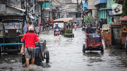 Warga beraktivitas saat banjir rob di Muara Angke, Jakarta, Jumat (25/11/2022). Badan Penanggulangan Bencana Daerah (BPBD) DKI Jakarta mengimbau agar warga di pesisir Jakarta mengantisipasi banjir pesisir atau rob selama 22-28 November 2022. (Liputan6.com/Faizal Fanani)