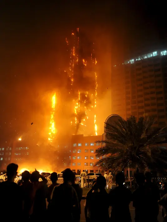 Sejumlah orang berkumpul melihat kebakaran yang melanda gedung apartemen mewah di Ajman, Uni Emirat Arab (UEA), Senin (28/3). Insiden kebakaran kali ini adalah yang ketiga selama Februari 2015 sampai saat ini. (REUTERS/Stringer)