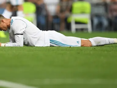 Penyerang Real Madrid, Cristiano Ronaldo berbaring di lapangan seusai kehilangan satu gol pada laga pekan lima La Liga melawan Real Betis di Santiago Bernabeu, Rabu (20/9). Real Madrid menyerah di tangan Real Betis 0-1. (GABRIEL BOUYS/AFP)