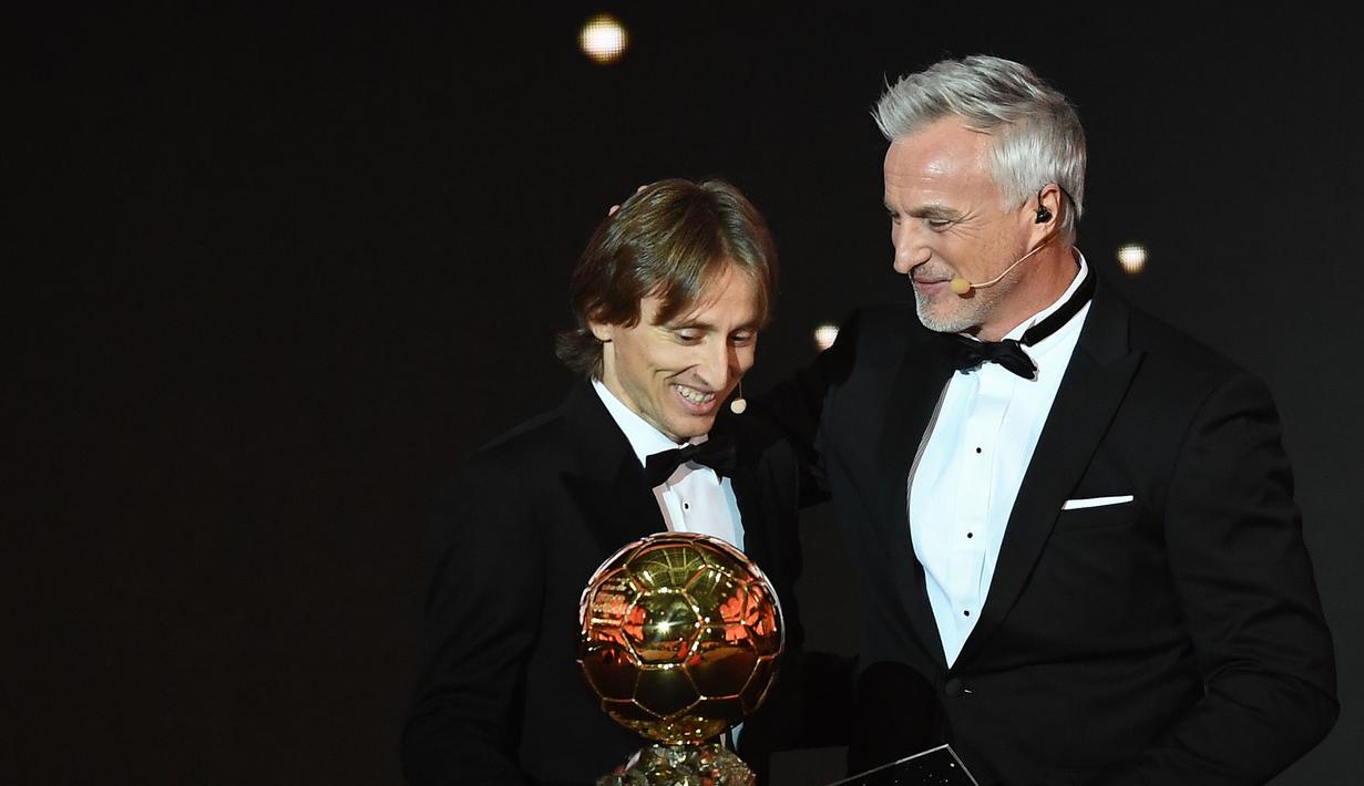 Gelandang Real Madrid asal Kroasia, Luka Modric, bersama legenda David Ginola saat malam penghargaan Ballon d'Or di Paris, Senin (3/12). Dirinya berhasil meraih gelar Ballon d'Or. (AFP/Franck Fife)