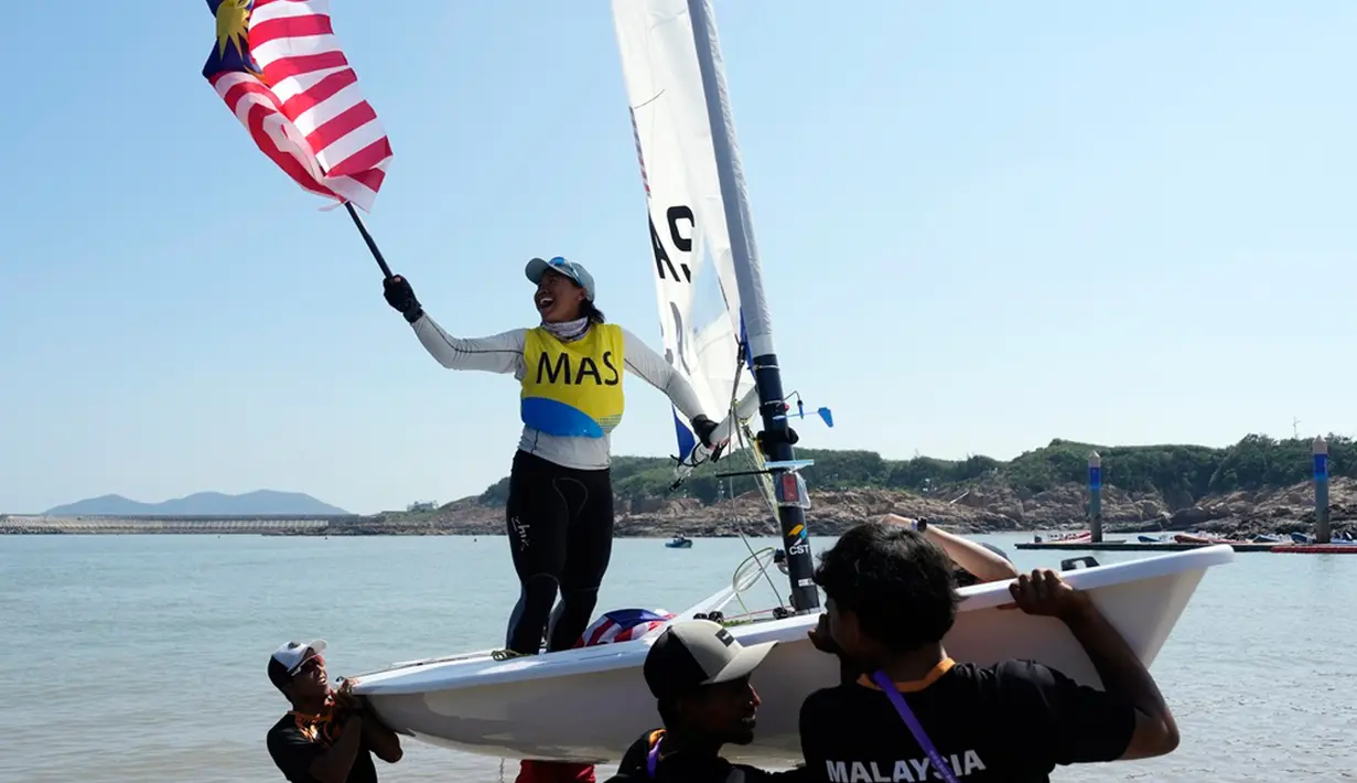 Nur Shazrin Binti Mohamad Latif dari Malaysia merayakan medali emasnya setelah perlombaan final kelas Single Dinghy - ILCA6 putri di Ningbo Xiangshan Sailing Center pada Asian Games ke-19 di Ningbo, China, Rabu (27/92023). (AP Photo/Eugene Hoshiko)