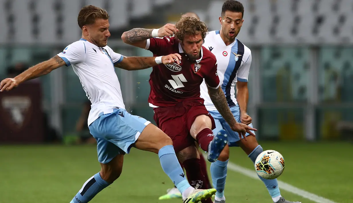 Bek Torino, Lyanco (tengah) berusaha melewati dua pemain Lazio pada pertandingan lanjutan Liga Serie A Italia di stadion Olimpiade di Turin (30/6/2020). Lazio menang tipis atas Torino 2-1. (AFP Photo/Isabella Bonotto)