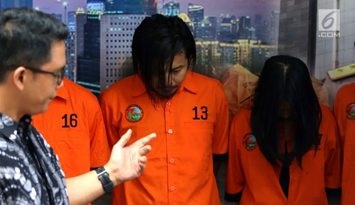 Vokalis grup band Zivilia, Zulkifli alias Zul (tengah) saat diperlihatkan petugas Ditresnarkoba Polda Metro Jaya, Jakarta, Jumat (8/3). Zul ditangkap bersama delapan orang lainnya. (Liputan6.com/Helmi Fithriansyah)