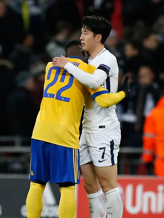 Pemain Juventus, Kwadwo Asamoah menghibur striker Tottenham Hotspur, Son Heung-Min setelah leg kedua babak 16 besar Liga Champions di Wembley, Kamis (8/3). Kekalahan dari Juventus membuat Heung-Min terlihat begitu emosional. (IAN KINGTON/AFP)