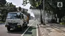 Petugas Palang Merah Indonesia (PMI) menggunakan kendaraan Gunners Spraying saat penyemprotan disinfektan di Jakarta, Selasa (6/7/2021). PMI melakukan penyemprotan disinfektan secara rutin dengan menggunakan kendaraan Gunners Spraying berkapasitas 5.000 liter. (merdeka.com/Iqbal S. Nugroho)