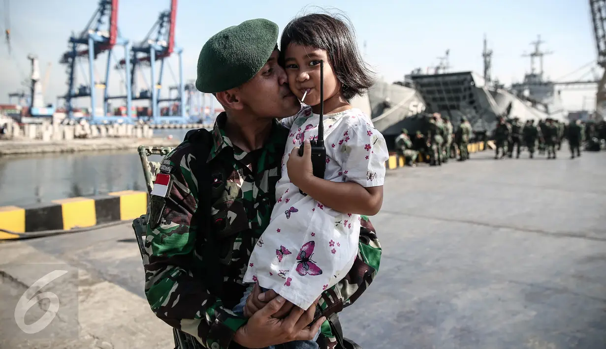 Seorang personel TNI-AD berpose dengan anaknya di Pelabuhan Kolinlamil, Jakarta, Senin (9/5). Sebanyak 450 personel TNI-AD dari Satgas Yonif Para Raider 330 inf 1 Kostrad dilepas untuk misi pengamanan perbatasan RI-PNG. (Liputan6.com/Faizal Fanani)