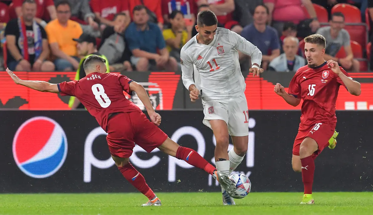 <p>Penyerang Spanyol, Ferran Torres berusaha melewati dua pemain Republik Ceko Jakub Pesek dan Michal Sadilek pada pertandingan kedua Grup A2 UEFA Nations League di Stadion Eden Arena, Praha, Senin (6/6/2022). Spanyol bermain imbang atas Ceko 2-2. (AFP/Michal Cizek)</p>