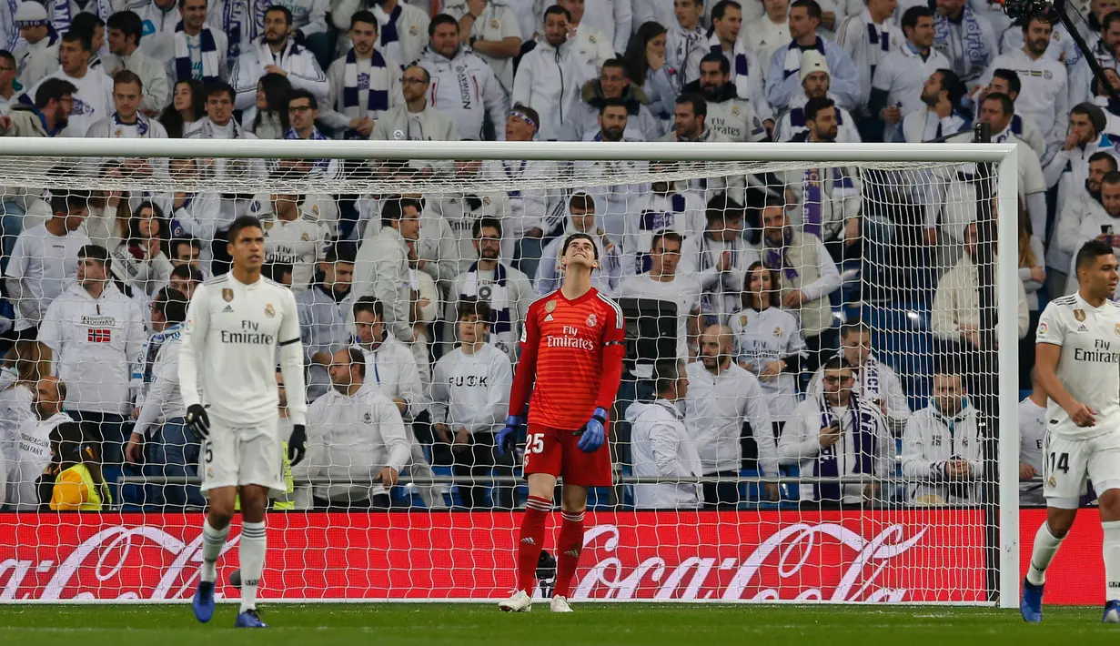 Ekspresi kiper Real Madrid Thibaut Courtois (tengah) saat kebobolan penalti pemain Real Sociedad pada laga pekan ke-18 La Liga Spanyol di Santiago Bernabeu, Minggu (6/1). Real Sociedad meraih kemenangan 2-0 atas Real Madrid. (AP Photo/Paul White)
