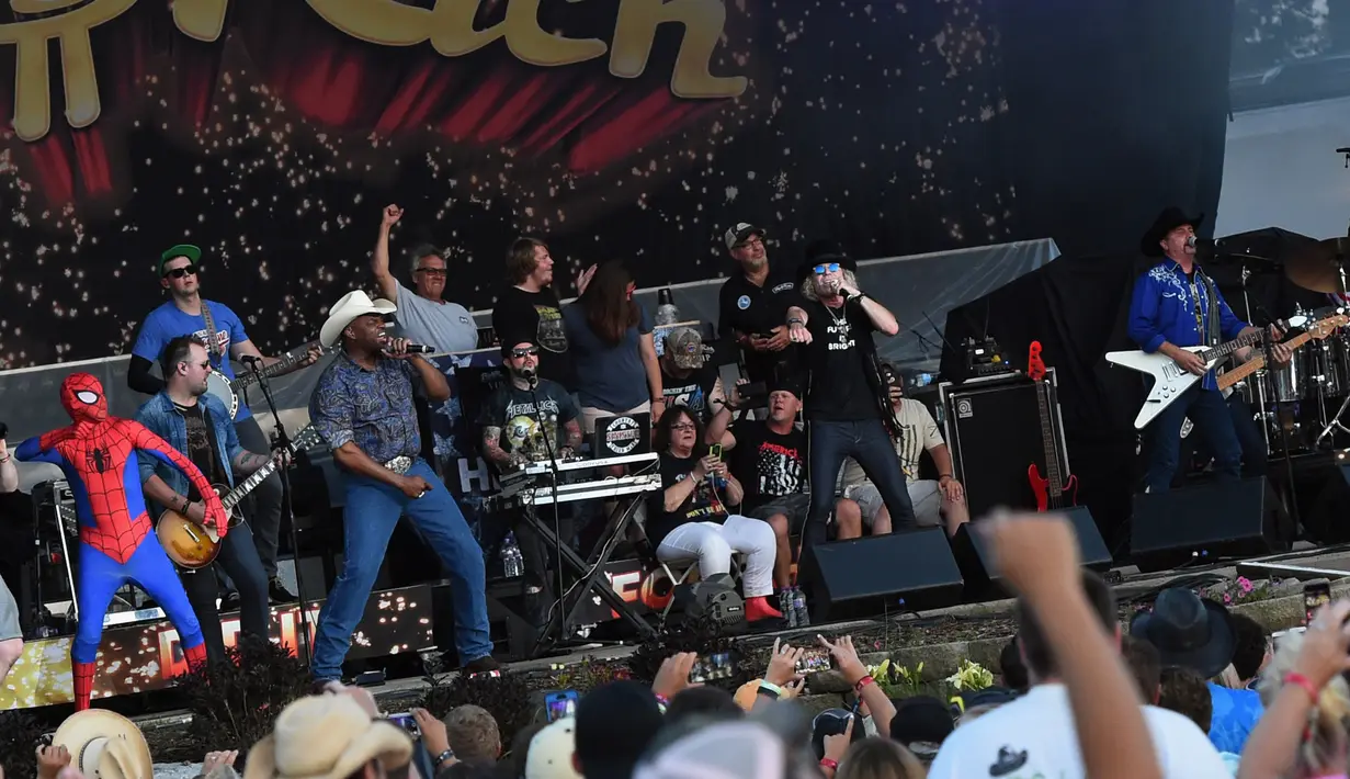 Aksi Spider Man di atas panggung bersama Cowboy Troy, DJ Sinister dan Kenny dan John Rich dari Big and Rich di atas panggung selama Thunder Country - Hari ke empat di Twin Lakes, Wisconsin (23/7). (Rick Diamond / Getty Images Country Thunder / AFP)
