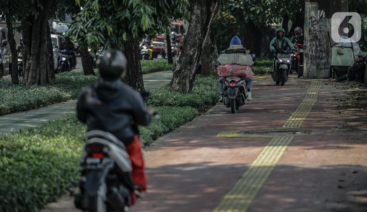 Sejumlah pengendara motor melintas di atas trotoar pejalan kaki di kawasaan Daan Mogot, Jakarta, Senin (26/4/2021). Padatnya volume kendaraan pada jam kerja di kawasan itu membuat sejumlah pengendara motor nekat menggunakan trotoar yang merupakan
hak bagi pejalan kaki. (Liputan6.com/Faizal Fanani)